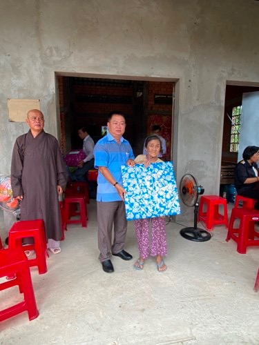 A group of people standing in a roomDescription automatically generated